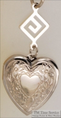 Silver-toned heart shaped locket with floral engraving & Greek key geometric pattern connector