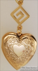 Gold-toned heart shaped locket with floral engraving & Greek key geometric pattern connector
